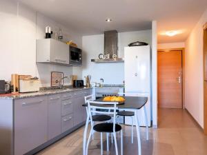 a kitchen with a table and some chairs in it at Winahost Apartment Neo Residencial Mediterráneo in Barrio-Mar +8 photos