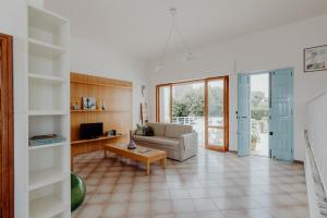 una sala de estar con un sofá y una mesa en Villa Elvira sul mare by Travel with Gianni, en Faccia di Trippa