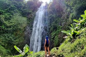 a woman standing in front of a waterfall at Bush and Forest Safari Retreat in Arusha