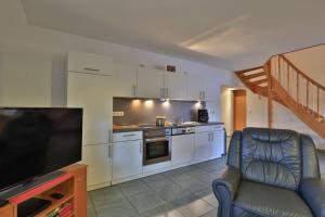 a living room with a television and a kitchen at Fischerhaus Whg Sonnenaufgang in Neukloster