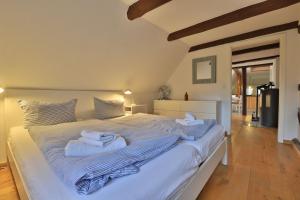 a bedroom with a large white bed with towels on it at Fischerhaus Whg Sonnenaufgang in Neukloster +43 photos