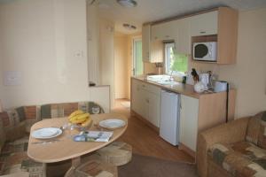 a living room with a table and a kitchen at Dinas in Llanbedr