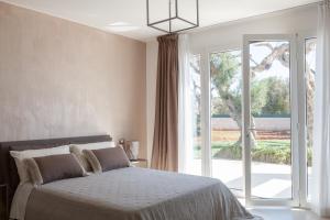 a bedroom with a bed and a large window at Villa Ghislena by salentoltremare in Marina San Gregorio