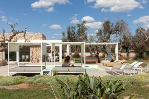 a woman sitting in a pavilion in a garden at Villa Ghislena by salentoltremare in Marina San Gregorio