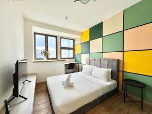 a bedroom with a bed and a colorful wall at Riveria City KL Sentral by Guestsupply in Kuala Lumpur