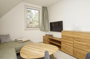 una sala de estar con un sofá y una mesa en Rex Rugia FeWo12-5 mit Schwimmbad und Saunanutzung im AHOI-Erlebnisbad Sellin, en Lobbe