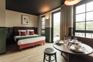 列日Getaway Liège的一间带床、桌子和餐厅的酒店房间