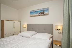 En eller flere senge i et værelse på Rex Rugia FeWo12-1 mit Schwimmbad und Saunanutzung im AHOI-Erlebnisbad Sellin + 23 billeder