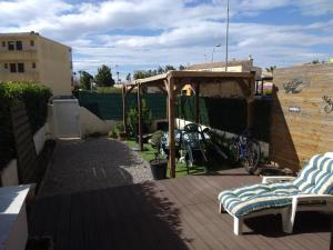a patio with two chairs and a gazebo at Résidence T2 , Jardin 100m plage Parking gratuit in Valras-Plage
