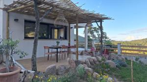 a patio with a table and chairs under a pergola at VILLA I BAGHI - sans vis-à-vis au calme in Sainte-Lucie de Porto-Vecchio