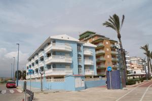 un edificio azul con una palmera delante de él en Barramundi, en Peñíscola