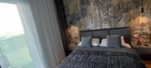 a bedroom with a large bed with blue pillows at GOLD APARTMENTS Panorama Kwiatkowskiego in Rzeszów