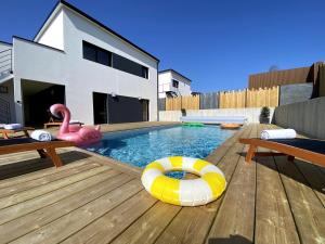 a swimming pool with a swan and a float in a backyard at Villa Au Rythme Des Marées in Carantec