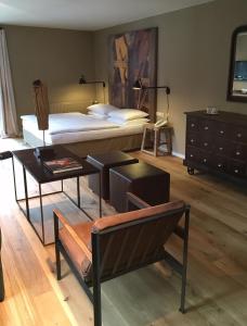 a bedroom with a bed and a table and a desk at Strandhotel Margaretha in St. Wolfgang