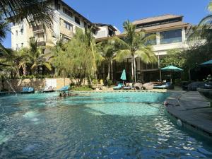 a swimming pool in front of a building at Avana Villa Jimbaran By Fays Hospitality in Jimbaran