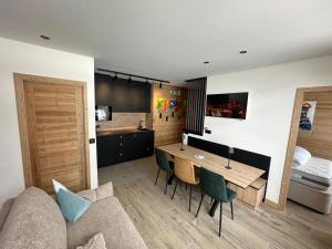 a living room with a couch and a wooden table at Zalona Altitude Appartement T3 - Emplacement exceptionnel - entrée indépendante - entièrement rénové in Tignes