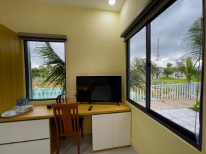 un bureau avec un bureau et une grande fenêtre dans l'établissement Sai Gon Ha Tien Resort, à Hà Tiên