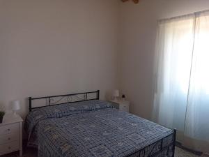 a bedroom with a bed and a window at Casa Agrumeto in Nunziata in Nunziata