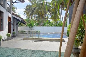 a swimming pool next to a building with a fence at Belmont Villa - Free Airport Shuttle Service in Negombo