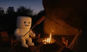 a stuffed snow man sitting next to a fire at Simply Camping in Hidden River
