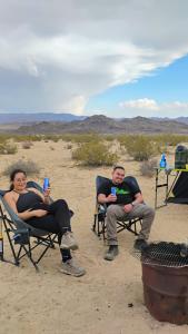 two people sitting in lawn chairs in the desert at Simply Camping in Hidden River +7 photos