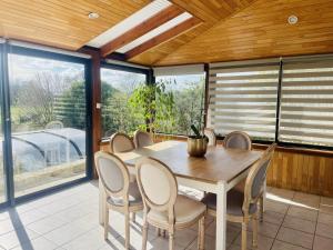 a dining room with a wooden table and chairs at La maison d'annie in Pléhédel