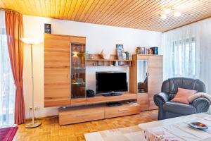 a living room with a large entertainment center with a television at Ferienwohnungen Tannengeflüster in Ühlingen-Birkendorf