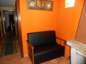 a chair in a room with an orange wall at Casa do Souto in Quinta do Souto