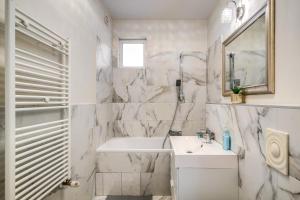 Un baño blanco con lavabo y espejo. en Akácfa 413 City Getaway, en Budapest 21 fotos más