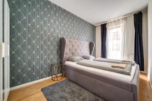 Un dormitorio con una cama y una pared. en Akácfa 413 City Getaway, en Budapest