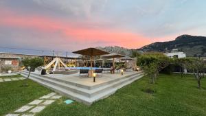 a patio with tables and umbrellas in a yard at LA Casa Di Lusso Casa N2 Adults Only in Kolimbia