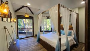 a bedroom with a canopy bed and a window at Sea Breeze, Guhagar in Guhagar