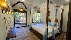 a bedroom with a canopy bed and a window at Sea Breeze, Guhagar in Guhagar