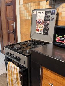 a kitchen with a stove with a magazine on it at Mima homes in Gatunga