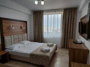 a bedroom with a bed with two towels on it at Hotel Laguna in Mangalia