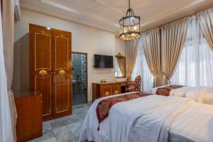 a hotel room with two beds and a tv at Stella Emelia in Timuran