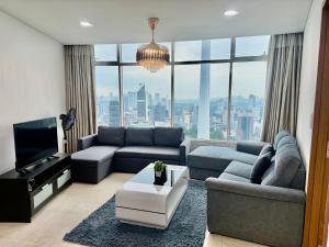 a living room with a couch and a tv at Vortex Premium Apartment klcc in Kuala Lumpur