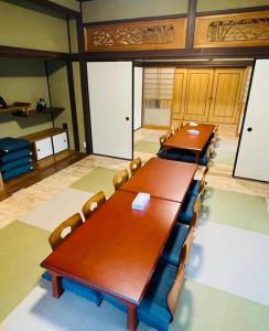 una sala de conferencias con mesas y sillas de madera en 時間を忘れる貸別荘ノースブルー, en Hiroshima
