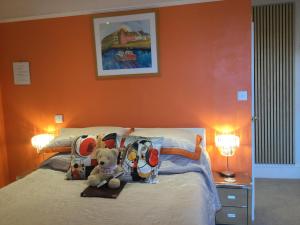 a teddy bear sitting on a bed in a bedroom at Arun Sands Rooms in Littlehampton