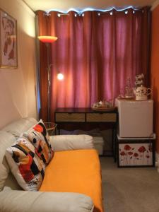 a living room with a couch in front of a window at Arun Sands Rooms in Littlehampton