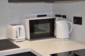 un microondas sentado en un mostrador junto a una tostadora en Cosy one bedroom APT- Free netflix, en Milton Keynes