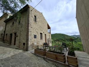 a stone building with two chairs and flowers on it at Luciae Domus in Roccascalegna