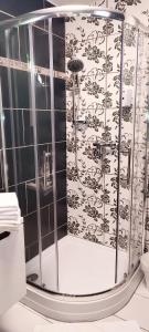 un bagno con doccia e piastrelle bianche e nere di Tinyhouses am Neusiedlersee a Fertőrákos Altre 37 foto