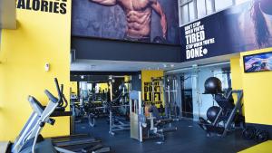 a gym with cardio equipment and a large sign at Signature 1 Hotel Tecom in Dubai +36 photos