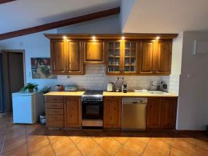 a kitchen with wooden cabinets and a stove top oven at Sisi apartman in Esztergom +17 photos