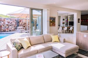 a living room with a couch and a kitchen at Coastal Cove Whale Watching Retreat in De Kelders