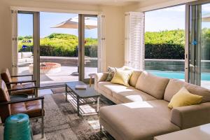 a living room with a couch and a pool at Coastal Cove Whale Watching Retreat in De Kelders