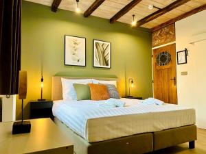 a bedroom with a large bed with a green wall at Landgoed De Hoogmolen in Opglabbeek