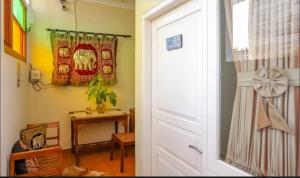 une porte menant à une chambre avec une table et une fenêtre. dans l'établissement Comfy Room Yogyakarta BY Hamsa Putih, à Yogyakarta