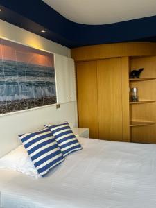 a bedroom with a bed with two blue and white pillows at SoBlue Hôtel in Antibes